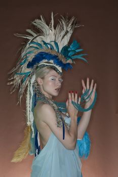 Portrait of young woman in feathered outfit over colored background