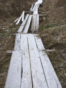 Destroyed wooden footway with hoarfrost
