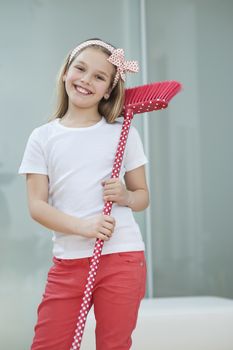Portrait of a happy young girl with broom