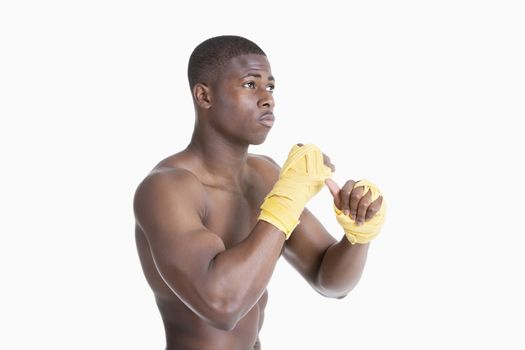 Shirtless African American kickboxer over gray background