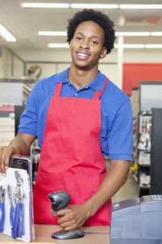 Portrait of an African American male store clerk standing at checkout counter