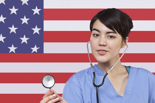 Portrait of mixed race female surgeon standing over American flag