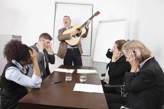 Businessman playing guitar in business meeting
