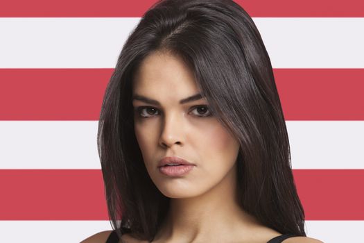 Close-up portrait of young woman against American flag