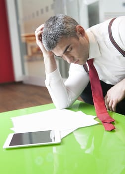 Businessman falling asleep whilst reading documents