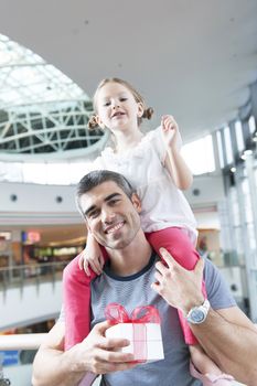 Young daughter sits on fathers shoulders