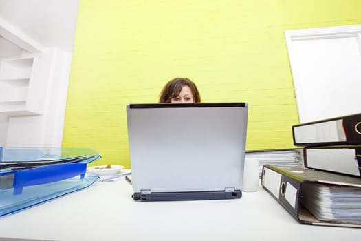 Womans head poking out over top of laptop