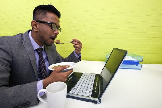 Indian businessman eating at his desk