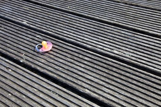 Dropped pacifier on wooden flooring