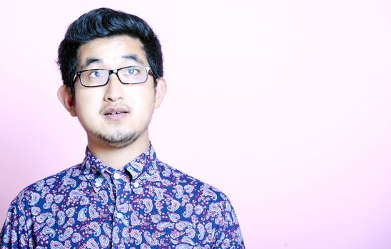 Young Geeky Asian Man in colorful shirt wearing glasses