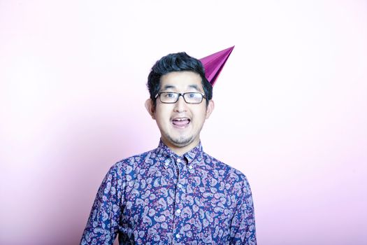 Young Geeky Asian Man wearing party hat