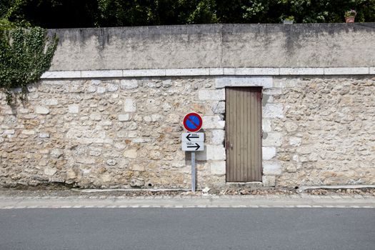 No parking sign against stone wall