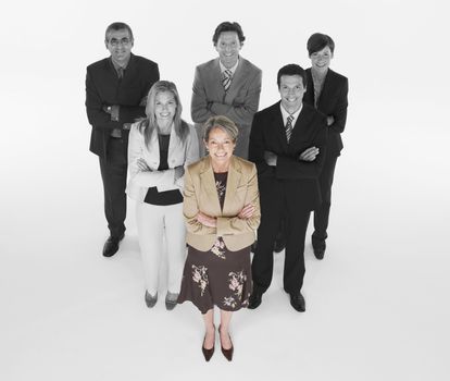 Ambitious businesswoman with team of professionals against white background