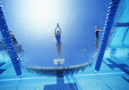 View of female swimmer diving in swimming pool