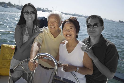 Happy Japanese family sailing together on yacht