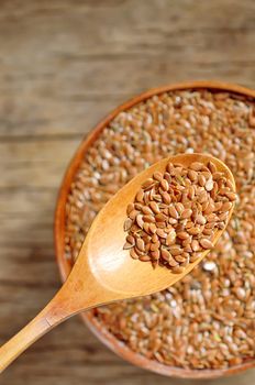 close up of flax seeds and wooden spoon 
