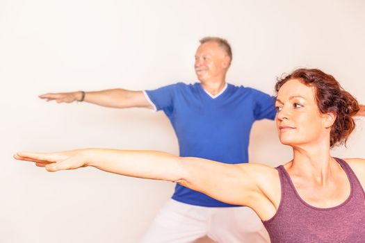 An image of a man and a woman doing yoga exercises