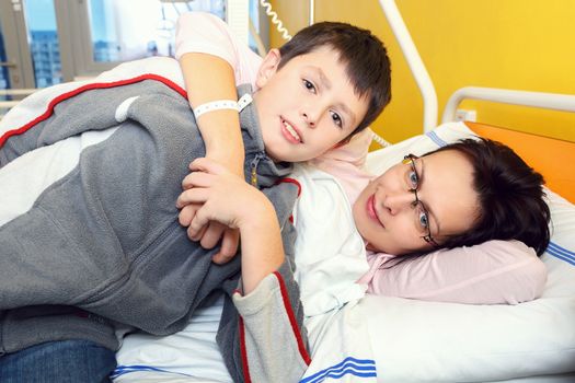 sad middle-aged woman lying in hospital with son