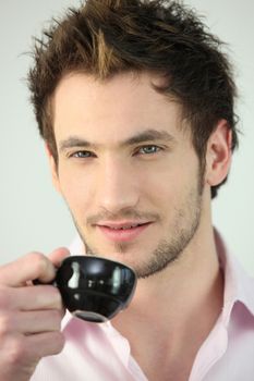Young man drinking a cup of expresso