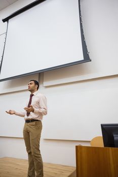 Male teacher against projection screen in lecture hall