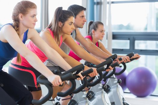 Four people working out at spinning class