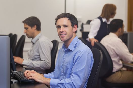 Attractive male student sitting in computer class
