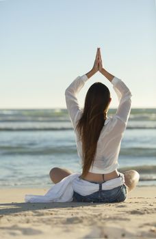 woman doing yoga on the beach