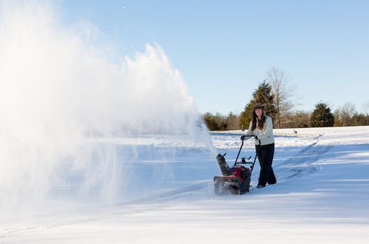 Young woman clearing drive with snowblower