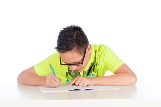 a teenage boy is writing in a exercise book on a white background