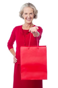 Cheerful old woman holding shopping bag