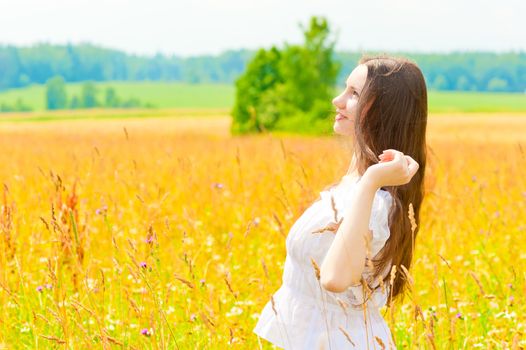 happy woman in a white sundress in the field
