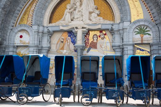 Loans of blue wheelchairs in front of the church within the Sanc