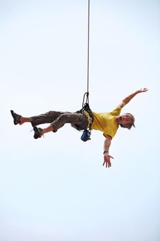 Happy rock climber hanging on rope