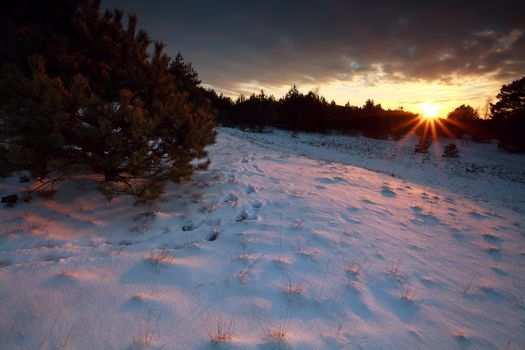 sunbeams over snowy hills at sunset