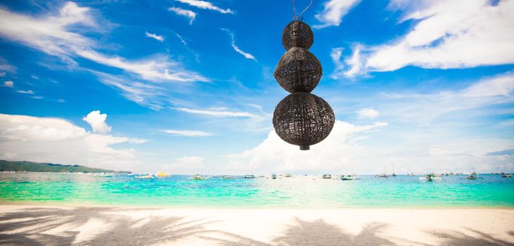 Unusual lantern on the white beach background blue sky