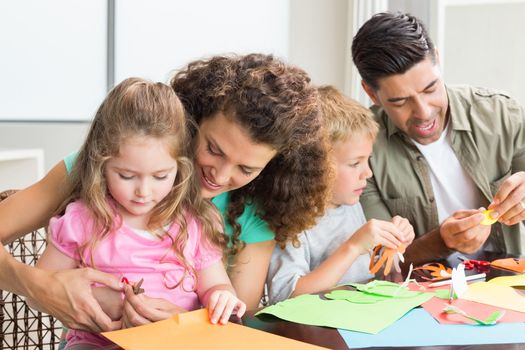 Cheerful family doing arts and crafts together at the table