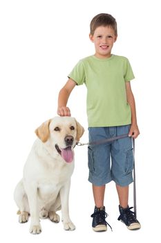 Cute little boy standing with his labrador dog smiling at camera