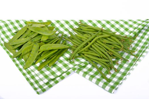 green beans and peas on a green towel
