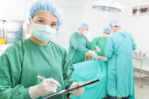 woman Surgeons writing medical record in operation room