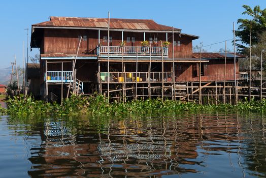 Traditional stilts house in water under blue sky