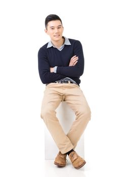Handsome Asian guy sit pose, full length portrait isolated on white background.