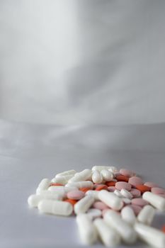 Group of pills on grey and white background.