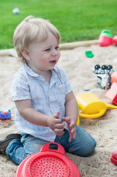 Small boy playing in sandpit