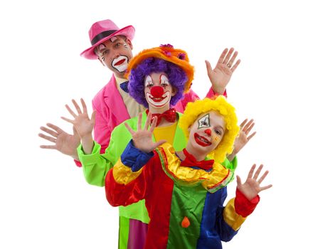 Three people dressed up as colorful funny clowns over white back