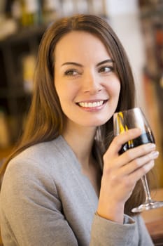 Portrait of pretty young woman drinking red wine in restaurant