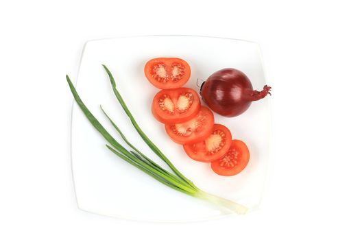 Spring onion and sliced tomato on the plate.