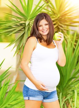 Pregnant woman eating apple