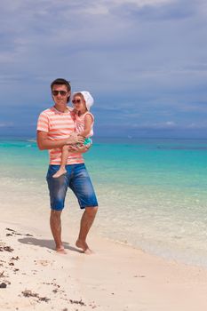 Cute toddler girl adn young daddy relaxing on white beach
