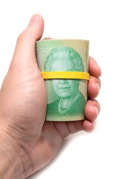 Hand holding a roll of 20 dollars Canadian