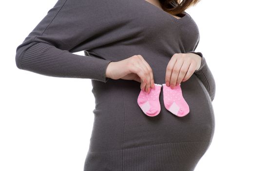 young pregnant woman in gray holding baby socks